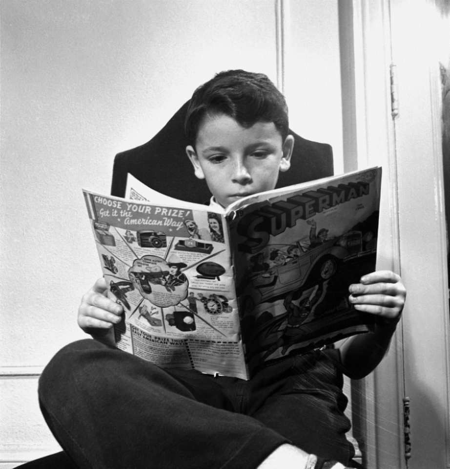 A young boy reading a Superman comic book, 1942.