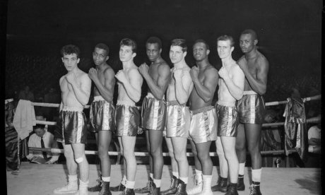 Boxers, possibly Golden Gloves contenders, lined up in boxing ring, c. 1955