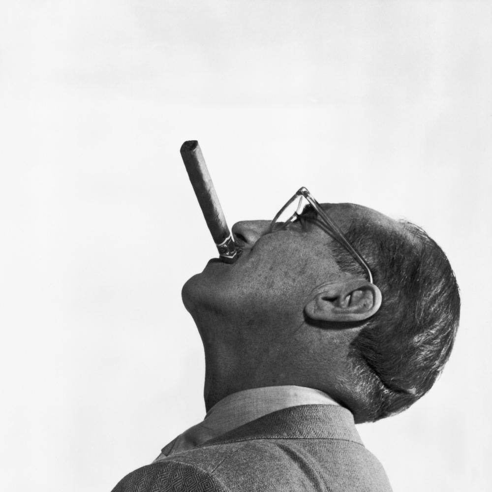 Side view of Groucho Marx, face tilted to the sky, smoking a cigar
