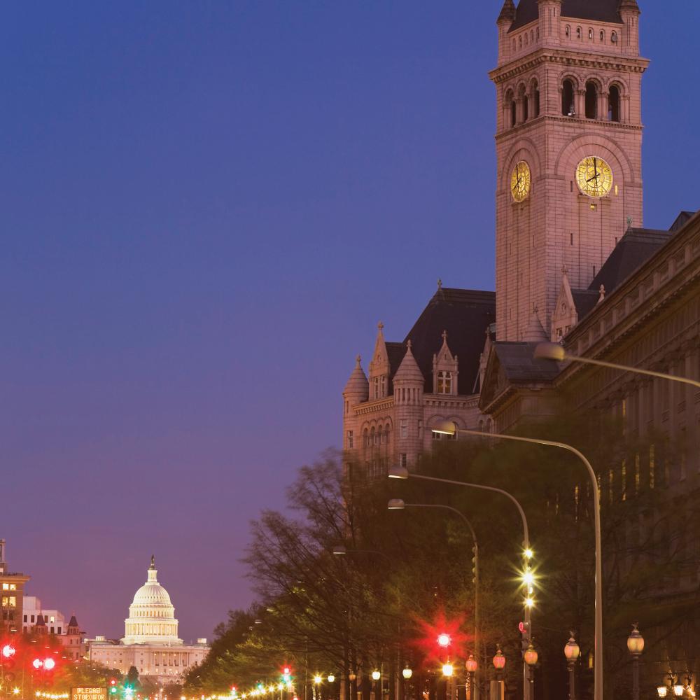 Photograph of clock tower, the United States capitol building at end of street