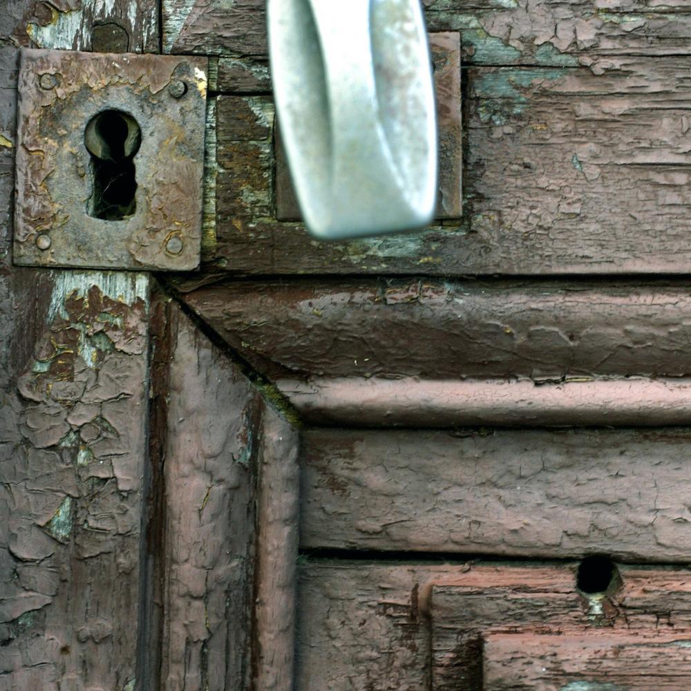 photograph of a wooden door with a bullet hole in it