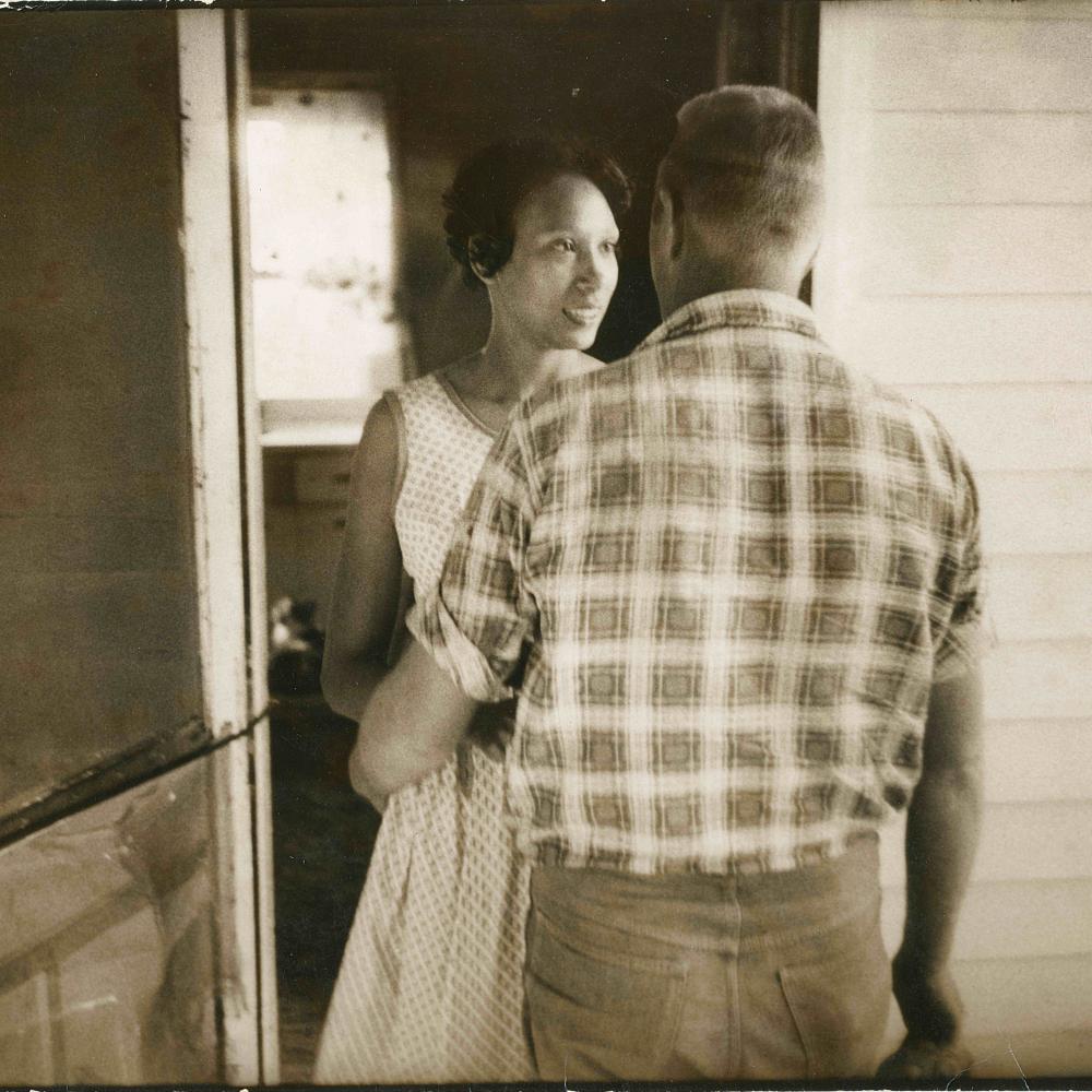 Sepia-colored photo of a man and woman in a doorway.