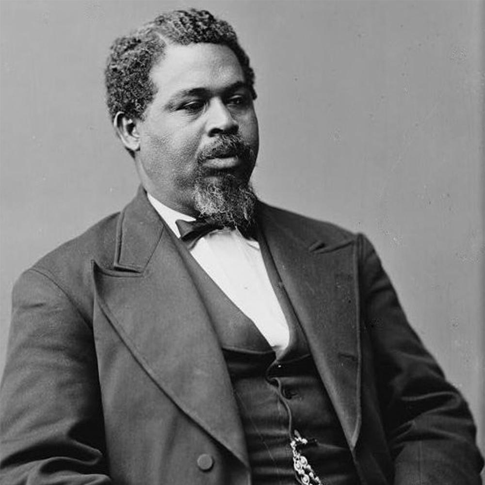Black and white photo portrait of Robert Smalls wearing a suit and sitting down.