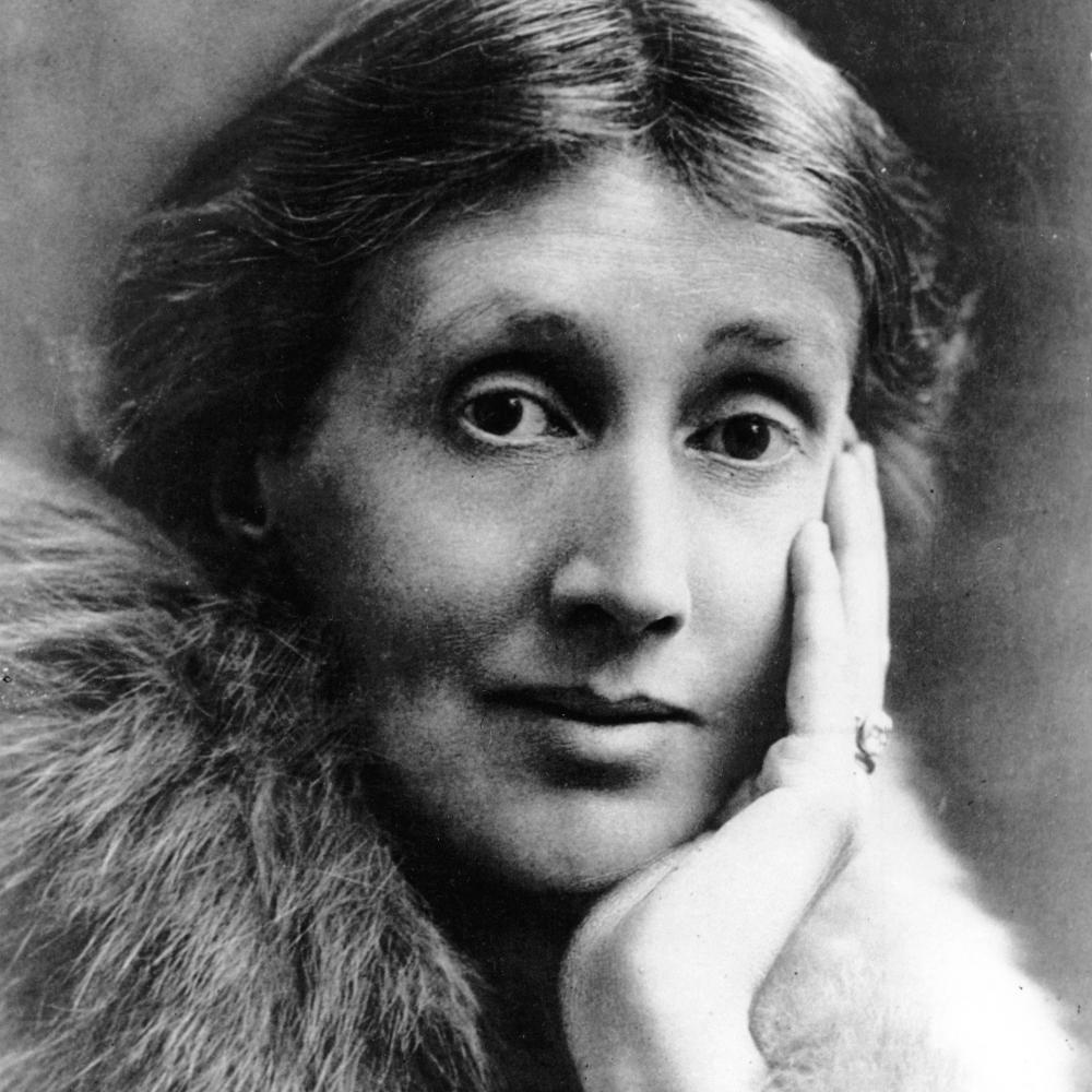 Headshot of Virginia Woolf, with her hair in a low bun, wearing a fur stole, and cradling her chin in her hand