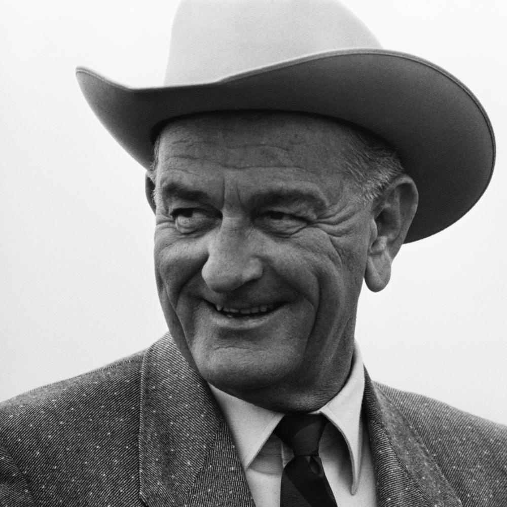 Black and white photo of a man in a suit smiling.