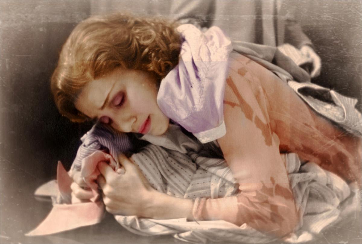 film still of a woman covered in shirts and weeping