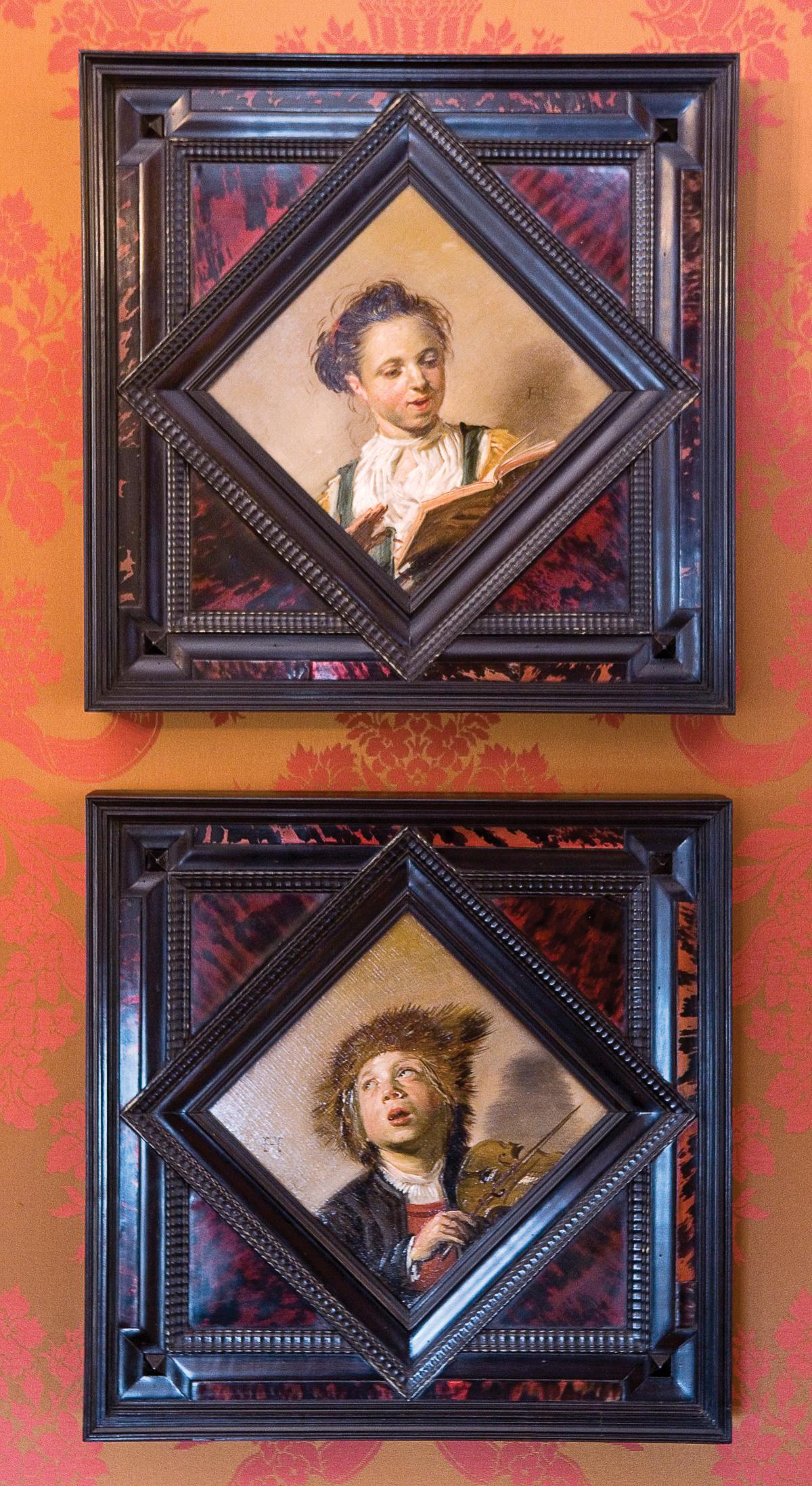two oil paintings framed, one of a girl singing, the other of a boy playing the violin