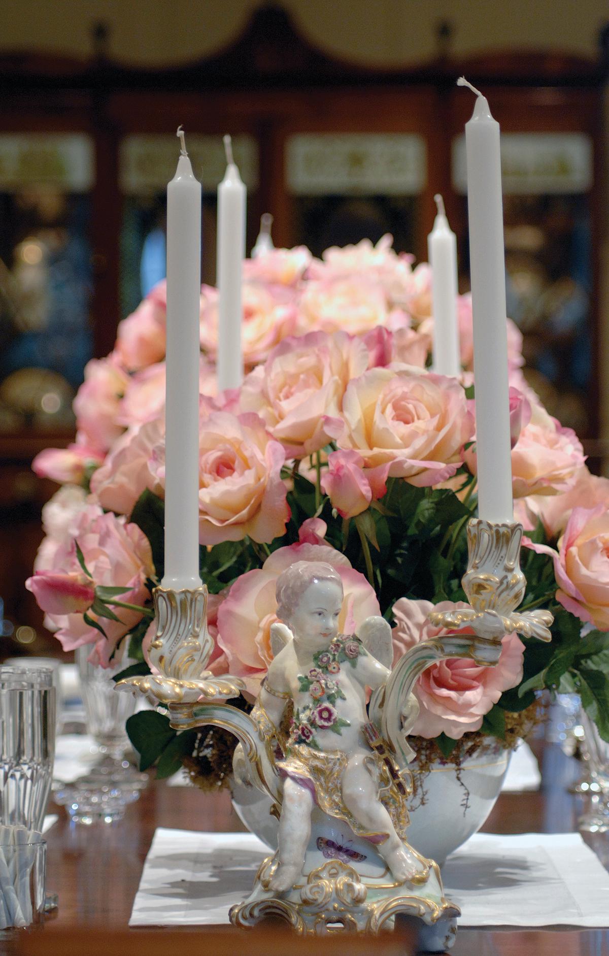 Photograph of candelabras, pink roses in a bouquet