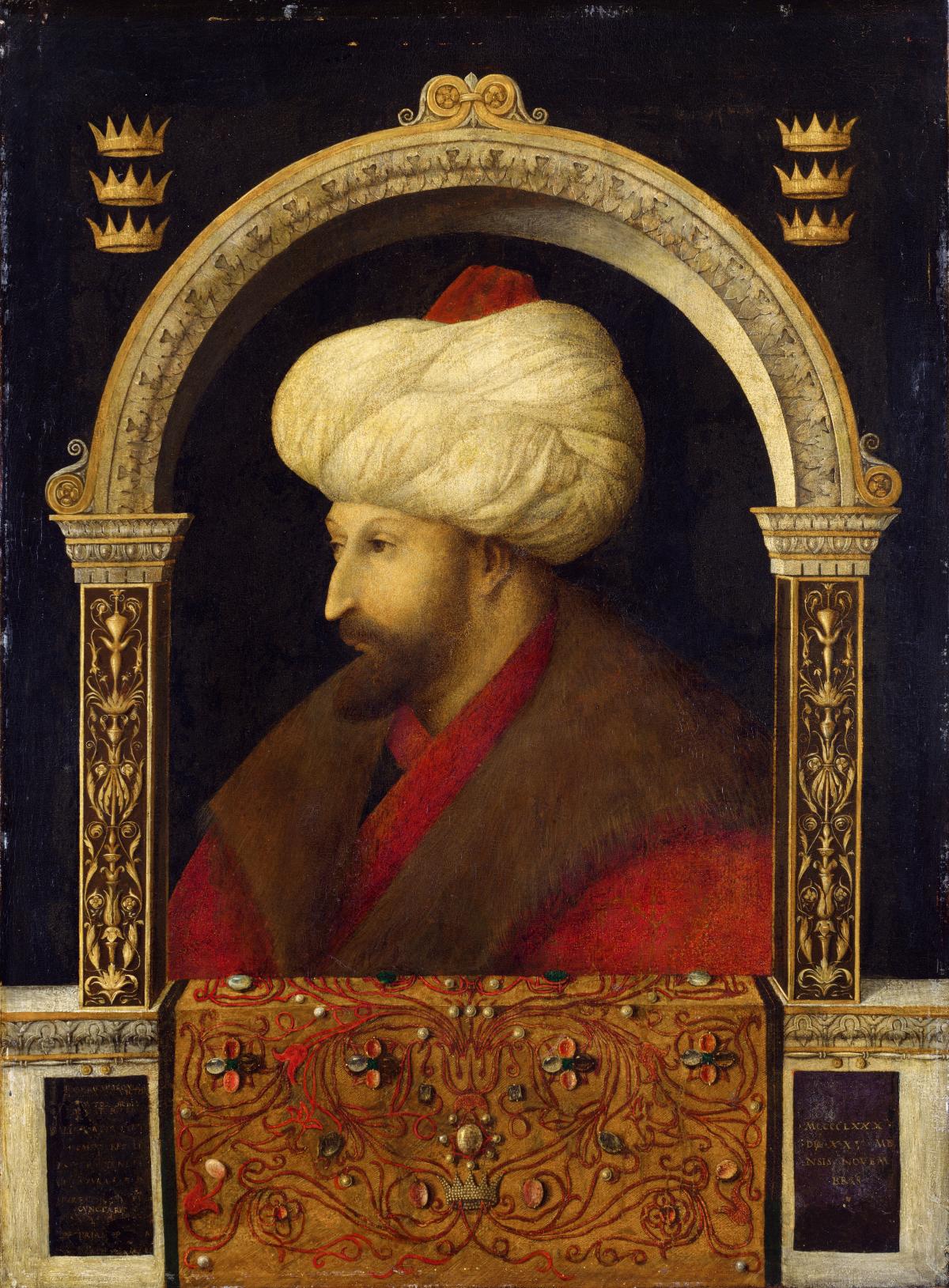 A man wearing a white turban, brown fur collar and red robe, framed by a golden arch