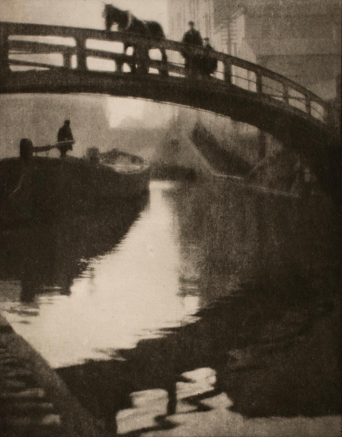 From the point of view of someone on the canal water: a bridge with a man and his horse crossing, with a boat up ahead, manned by a single figure, all in shades of black and beige