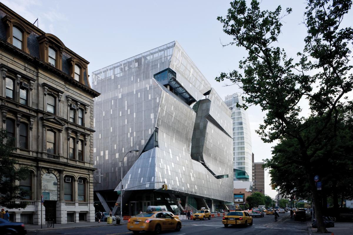 the new building is created out of silver rectangular panels, with parts of the wall curved inward