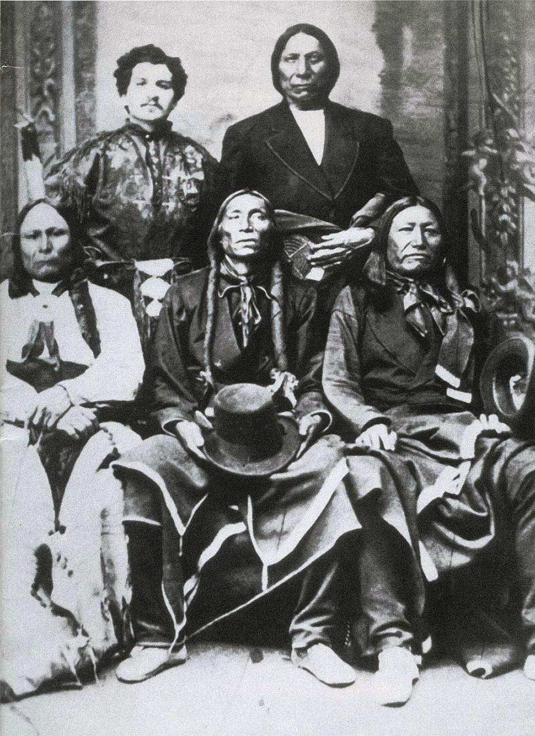 Three seated Pawnee chiefs in traditional clothing, with Mayer and another chief in a western style suit standing behind them, 