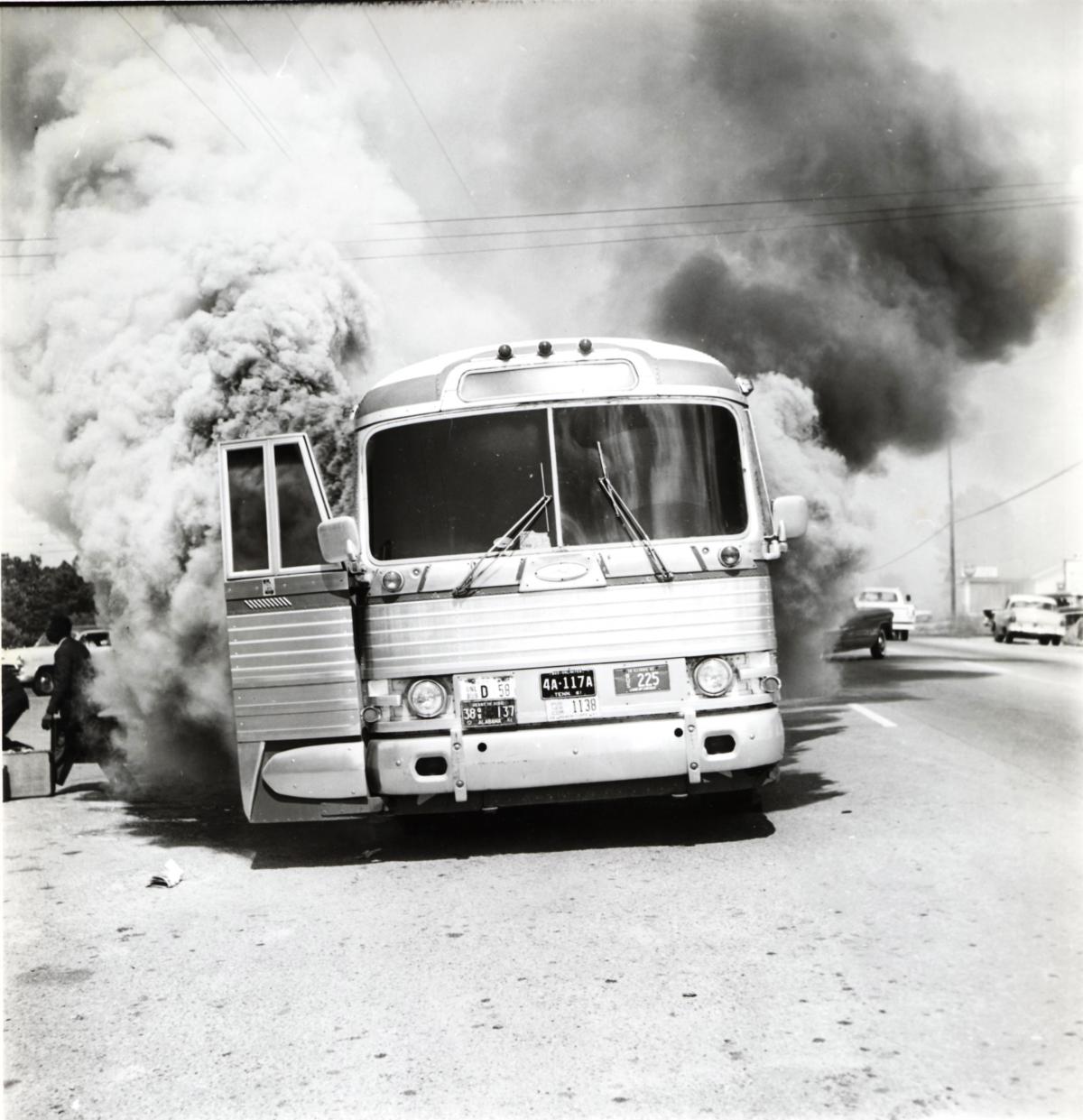 Smoke billows out of a Greyhound Bus with its doors wide open
