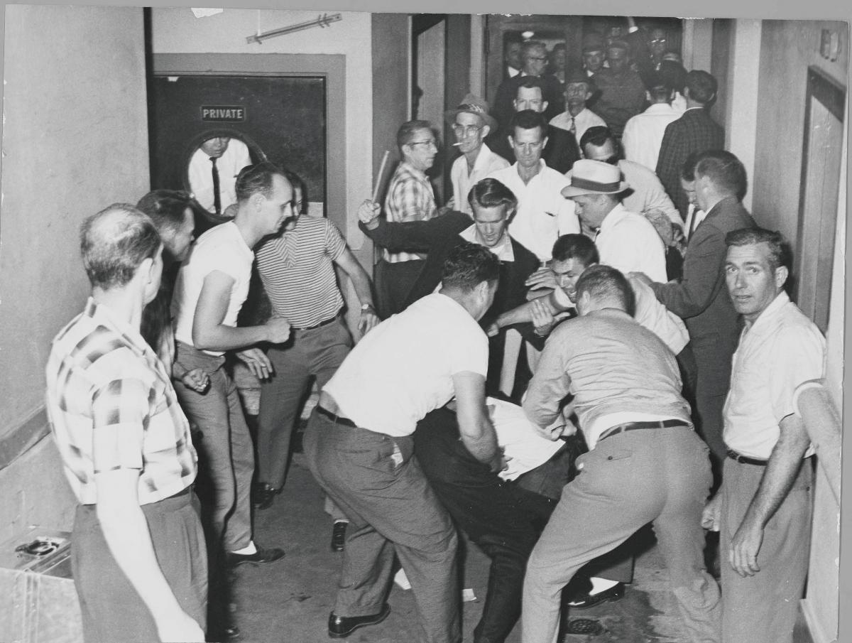 A fight between whites and African Americans; several bystanders watch