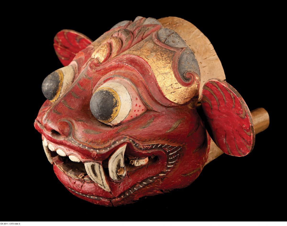 red and gold lion mask, with bulbous eyes and sharp fangs