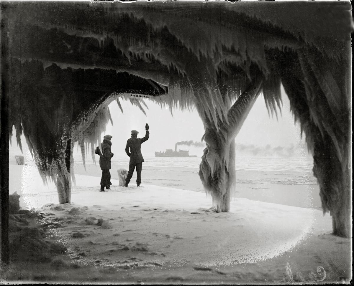 Two men examine the ice buildup, which has formed long icicles