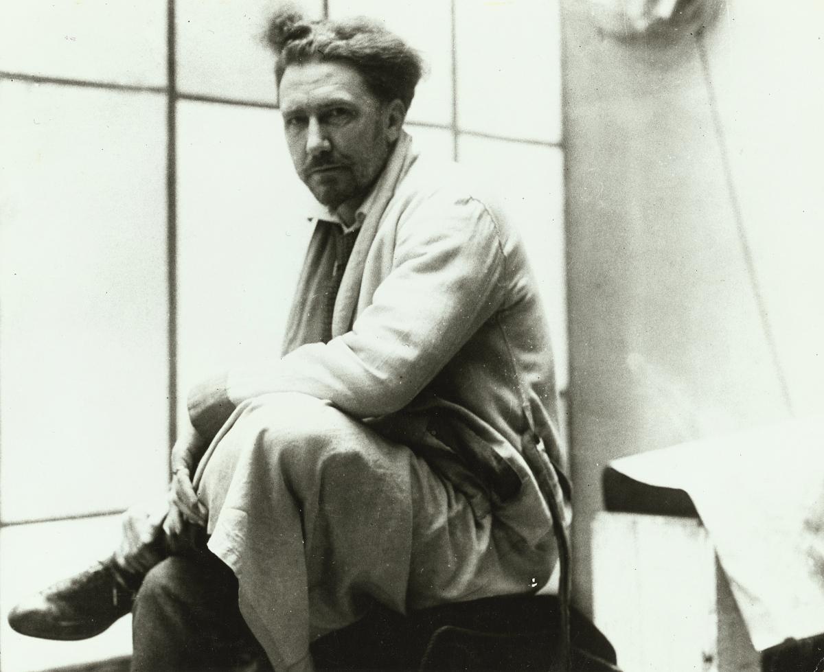 black and white photo of one of Ezra Pound, sitting with his legs crossed