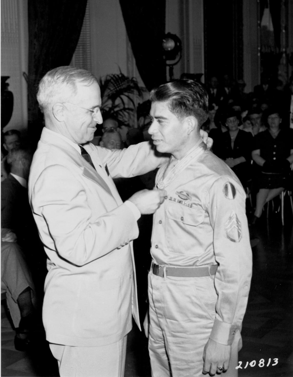 President Truman places the medal around Garcia's neck