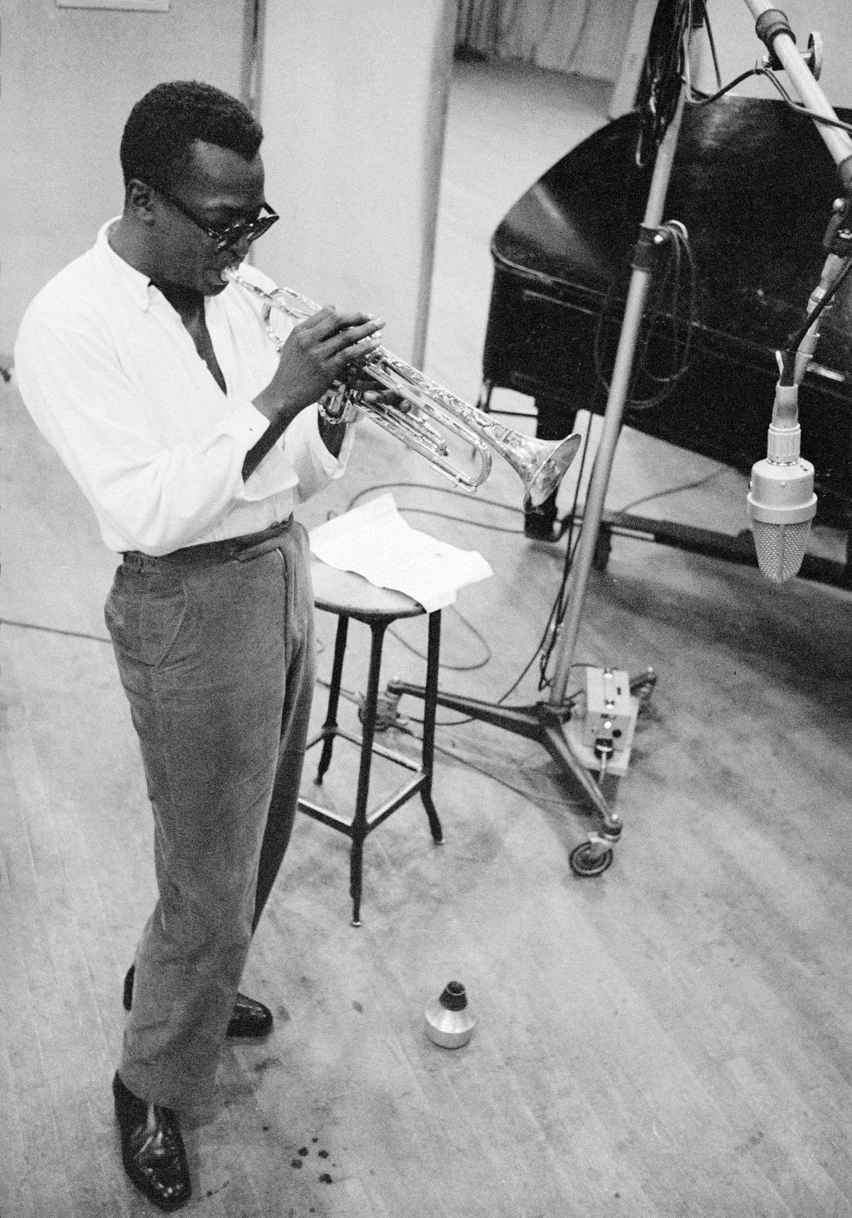 Davis, playing a trombone, wearing dark glasses