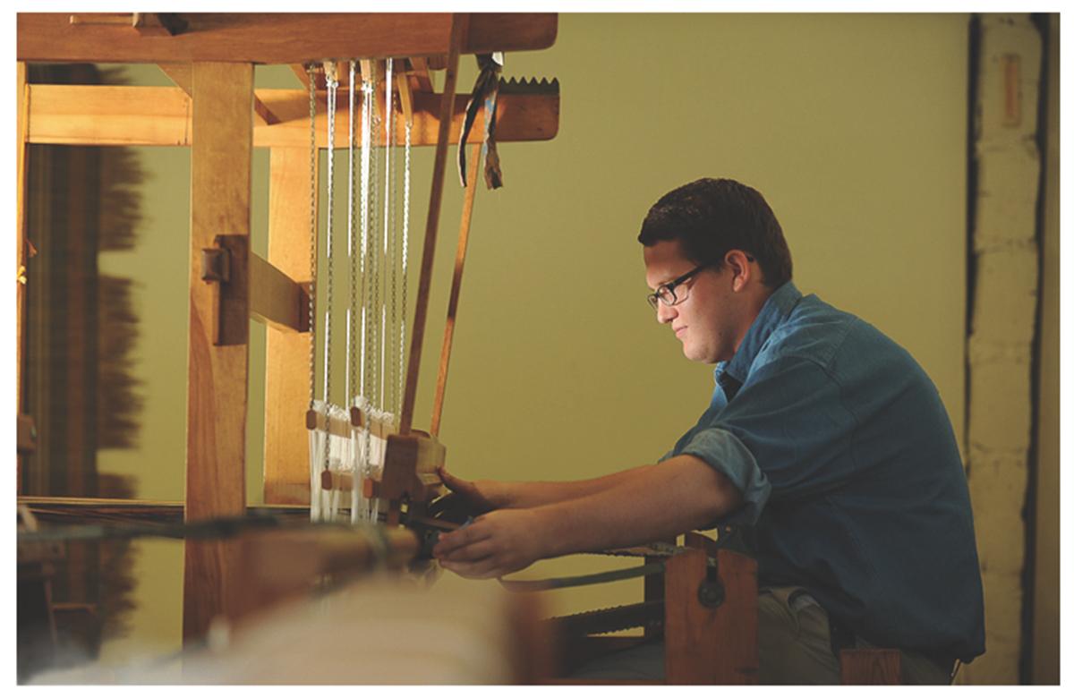 A student works at a wooden loom