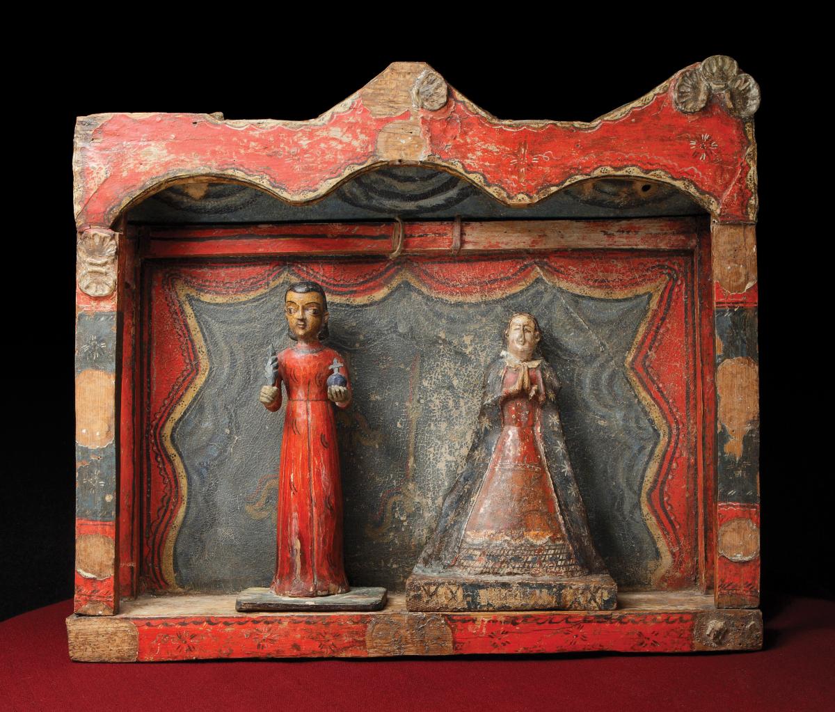 two wooden figures of saints, framed in a red wood