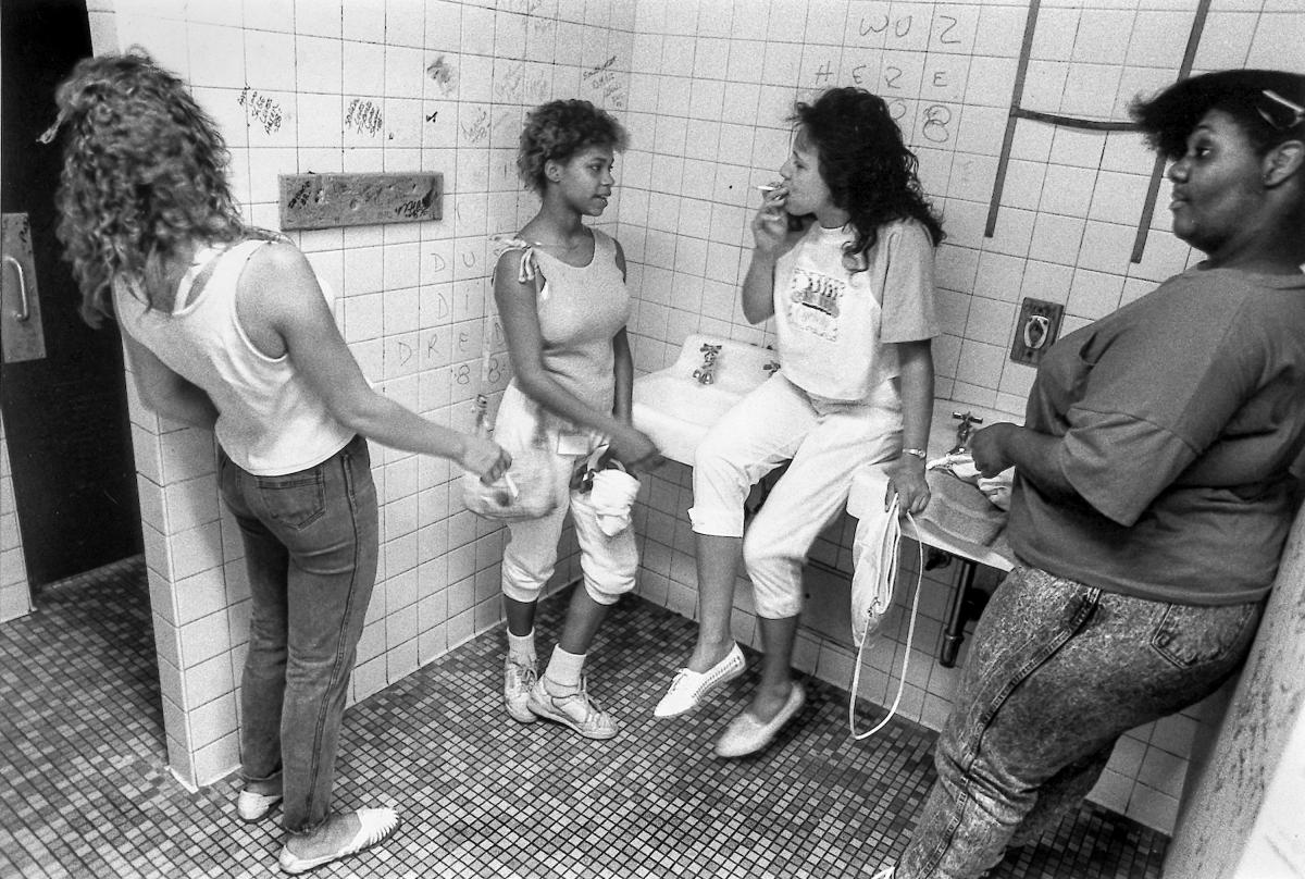 Black and white photograph of four girls in a high school bathroom