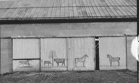 black and white photo of a barn with horses painted on doors