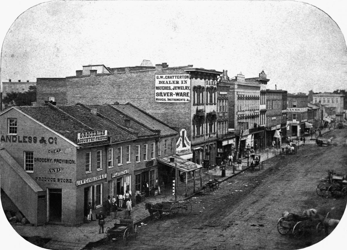 Black and white photograph of buildings in downtown city block, 1869