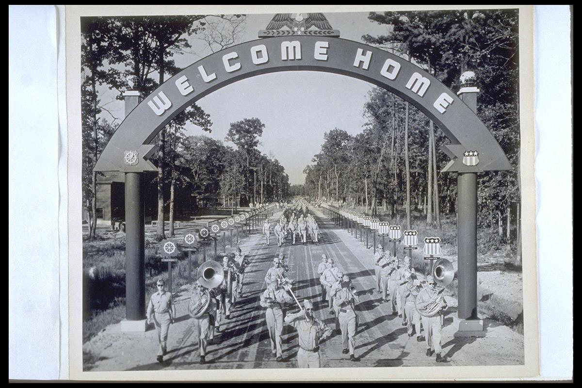 Arriving troops of the 10th Mountain Division March under the "Welcome Home" Arch at Camp Patrick Henry, Virginia