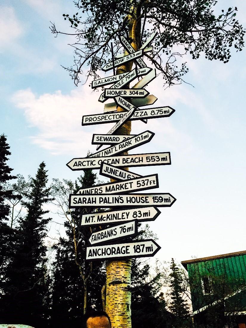 Road signs showing directions to Juneau, Fairbanks, and other popular locations in Alaska.