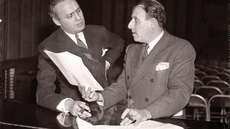 Black and white photo of Jack Benny and Harry Conn discussing what seems to be a contract