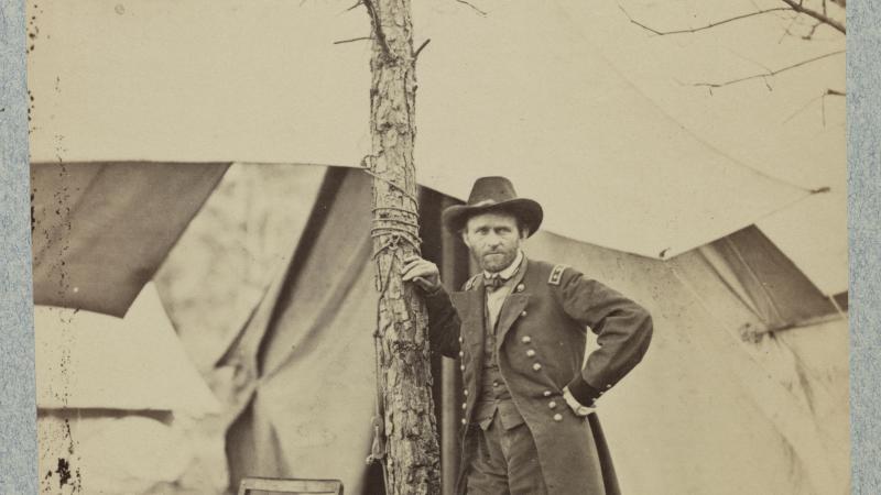 Grant at his headquarters in Cold Harbor, Virginia, in June 1864. Leaning on a tree, in front of several tents