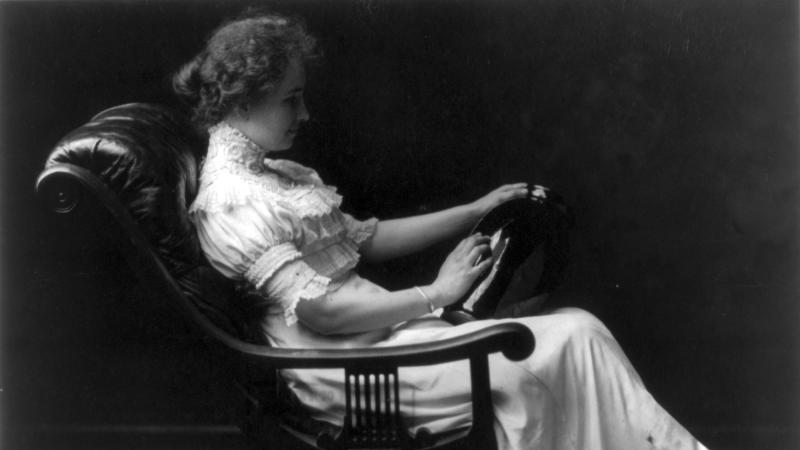 Black and white photo of Helen Keller sitting in chair