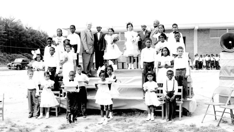 black and white photo of children standing on platform