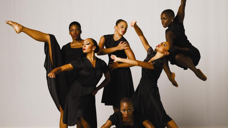 Six women dressed in black, in various dance poses