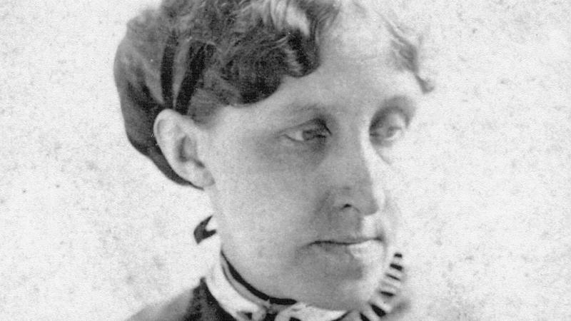 Alcott looking to her left shoulder, wearing a small ruffled collar and dark dress, with her hair in a low chignon