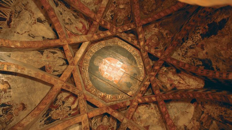 interweaving beams surround paintings of saints, decorated with gold