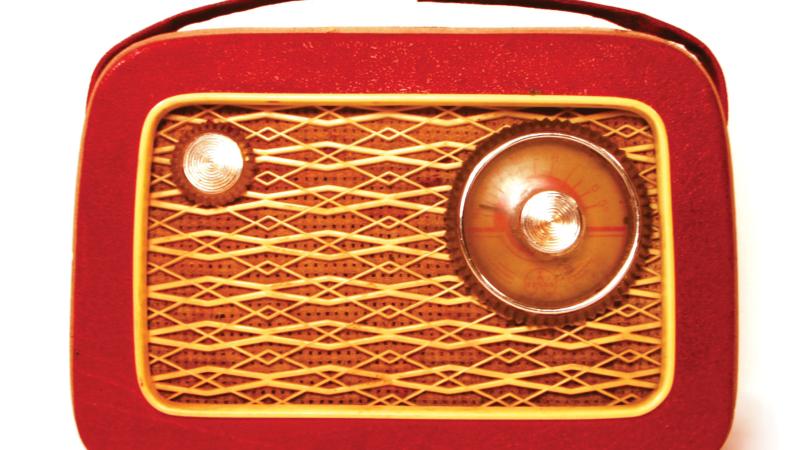 Red and wood-paneled radio, with a small handle attached to the top