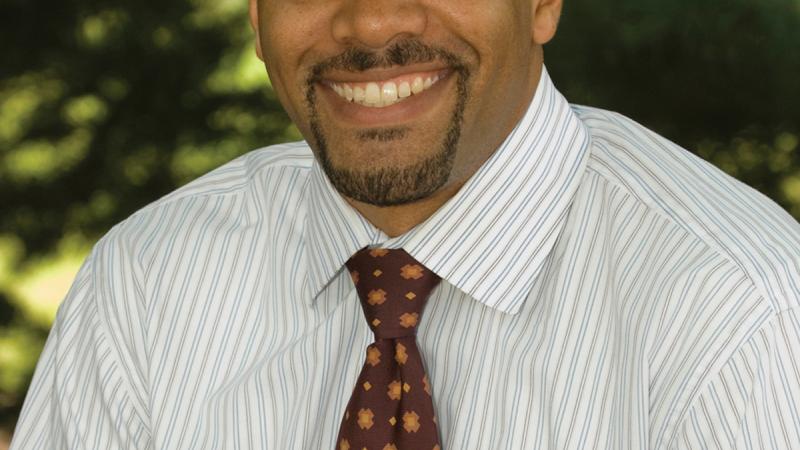 Color photo portrait of Chad L. Williams in a white shirt and burgundy tie.