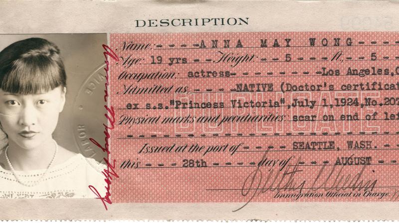 An identification card with a photo of movie actress Anna May Wong on the left and demographic information on the right.