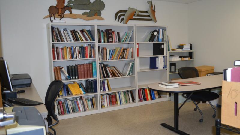 photo of room with bookshelf, desks