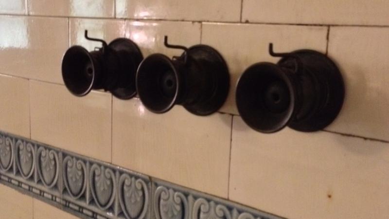 Speaking tubes fastened to a tile wall