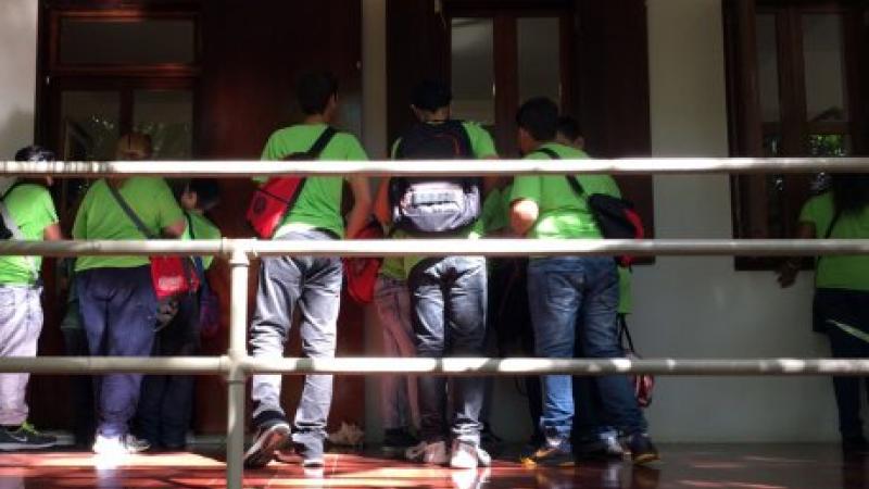 photograph of kids in green shirts entering a house