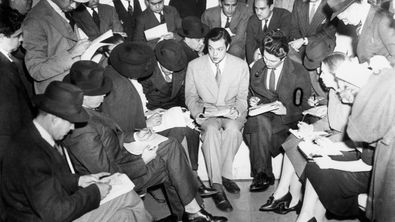 Orson Welles in the middle of journalists