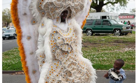 A color photo of a Mardi Gras Indian dressed in full costume