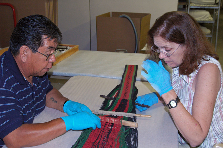 Conservator and Hopi weaver working on a piece