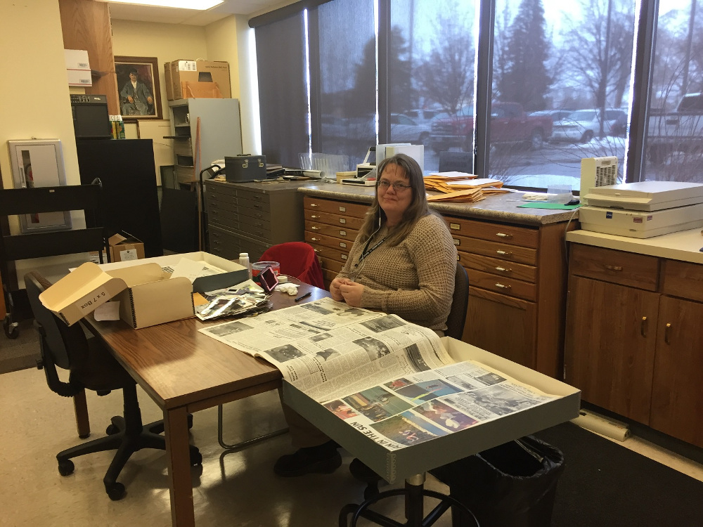 Michele Wheeler working on identifying Vernal Express photos using newspapers.