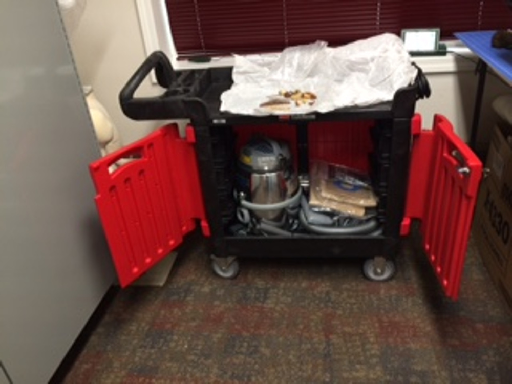 Collections Cleaning Cart in use, showing locked cabinet for Nilfisk vacuum.