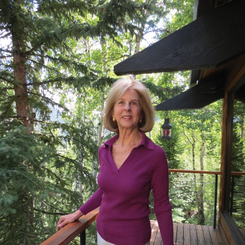 Elaine Pagels on a balcony, surrounded by forest