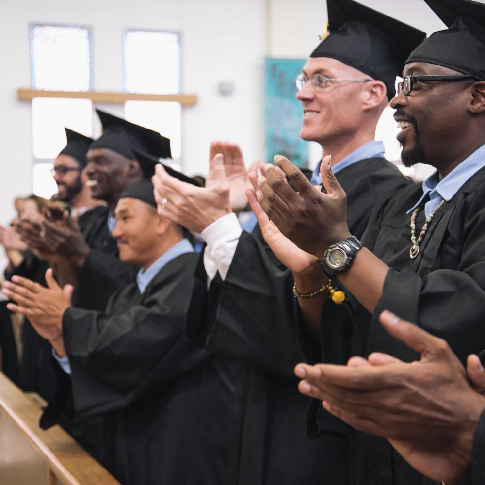 Graduates of the Prison University Project, clapping